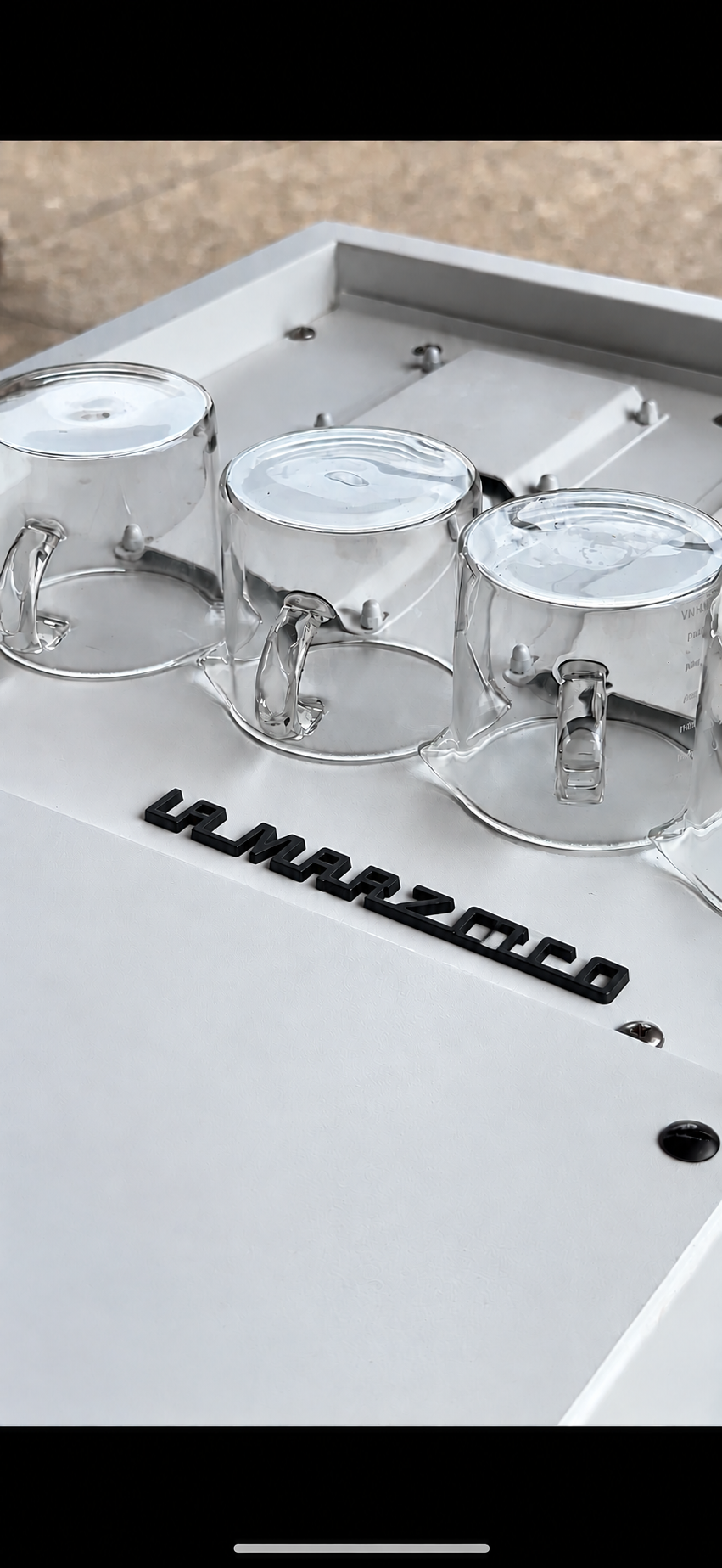 Italian espresso machine with three glass cups on its white drip tray